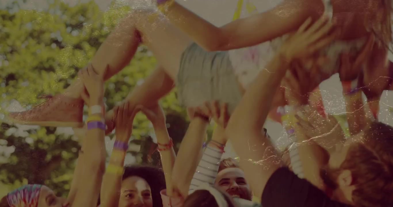 Festivalpublikum hæver arme og løfter kvinde, bevæger sig sidelæns og sænker hende derefter midt blandt armbånd, jublende