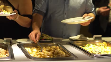 restaurant guests select food from a buffet