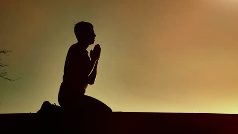 el hombre religioso se inclina al atardecer.