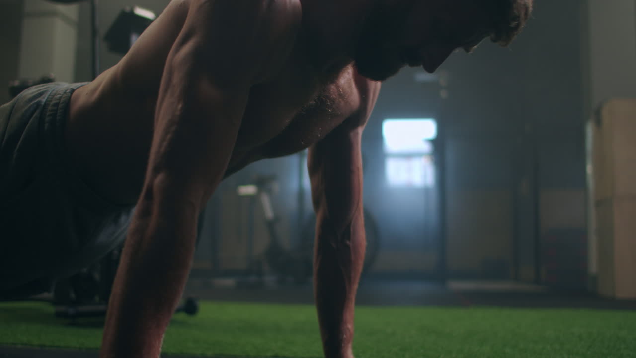 a strong purposeful man performs push-UPS despite fatigue and pain overcoming difficulties. the concept of a healthy lifestyle