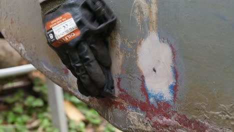 hands wiping down sanded fiberglass transom with acetone
