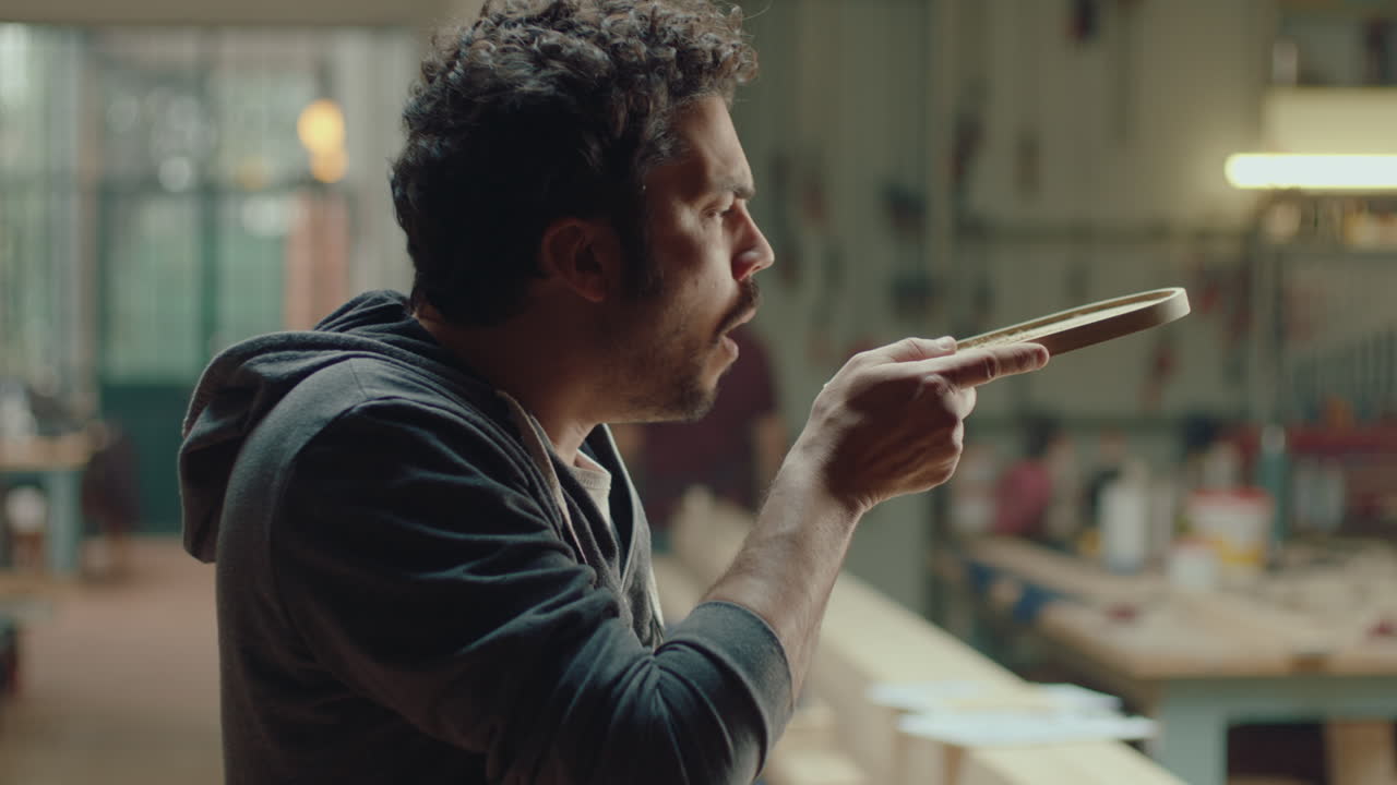 Woodworker Blowing Sawdust and Touching Wooden Tray
