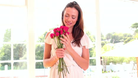 Pretty-woman-smelling-bouquet-of-roses