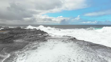 Aerial-shot-flying-low-over-a-rock-shelf-on-the-Victorian-coast-with-waves-pounding-against-the-rocks