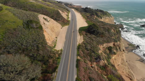 aerial of motorcyclist riding on california coast highway one