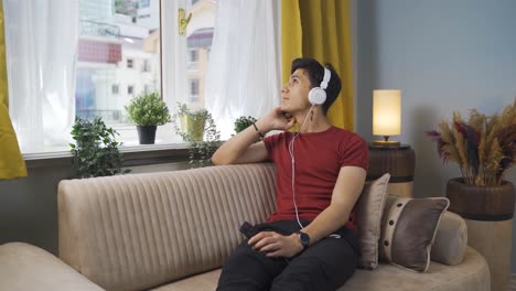 unhappy man listening to music with headphones.