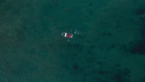 birdseye view of rowboat, fishermen in orange maritime suits rowing, open ocean