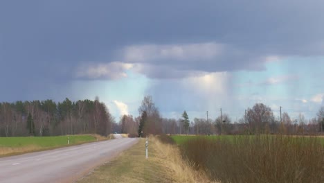 asphalt road in the countryside, thunder visible in the sky