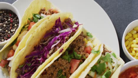 Video-of-freshly-prepared-tacos-lying-on-plate-on-grey-background