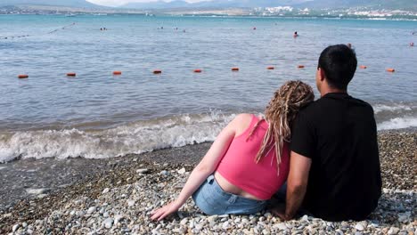 couple relaxing on a pebble beach