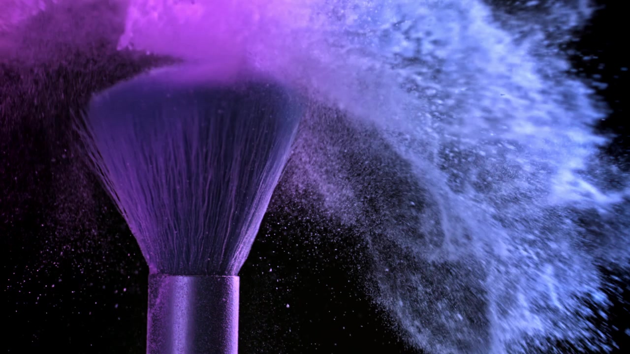 Vibrant Purple and Blue Cosmetic Powder Exploding from Makeup Brush