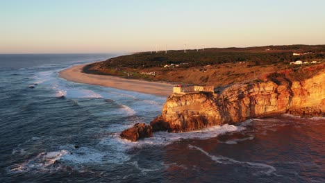 Nazare-Portugal-Leuchtturm-In-Der-Nähe-Von-Praia-Do-Norte-Während-Des-Sonnenuntergangs,-Luftkreispfanne