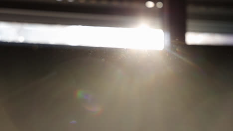 hand passing in front of camera moving dust particles against sunlight. gimbal, blur