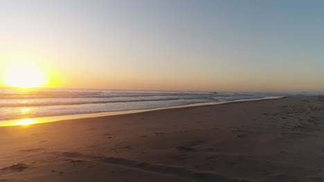 Drone-Volando-Bajo-A-Lo-Largo-De-La-Costa-De-La-Playa-Con-Surfistas-Corriendo-Para-Atrapar-Una-Ola-Con-Un-Hermoso-Amanecer-En-El-Fondo-En-Southport-Gold-Coast-Qld-Australia