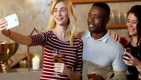 Friends-holding-drink-glass-making-funny-faces-while-taking-selfie-4K-4k