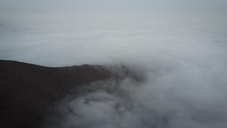 tiro de dron descendente de niebla en un día ventoso en una montaña en lima perú