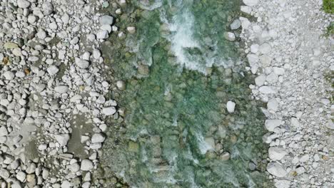 stream flowing over rocks and pebbles in silvaplana, switzerland - top view