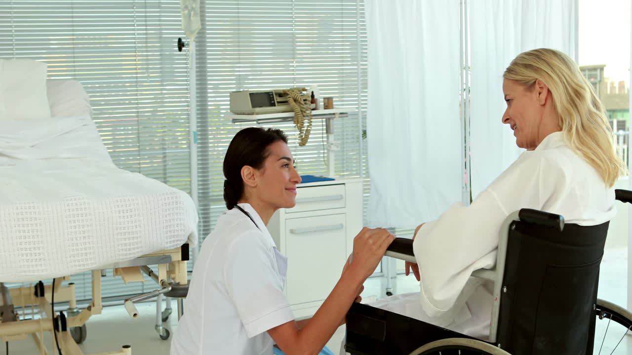 el médico habla con el paciente en silla de ruedas