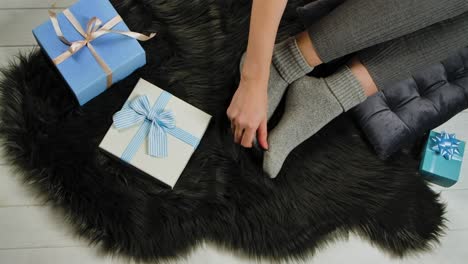woman relaxing with gifts on a fur rug