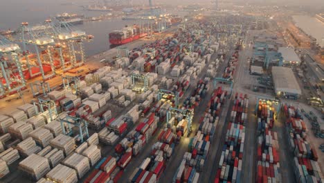 Stacked-freight-containers-and-cargo-cranes-aerial-view-orbiting-Port-of-Algeciras,-Cadiz-commercial-port