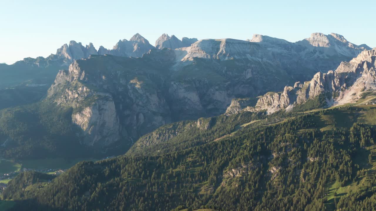 Aerial view showing green covered mountains at Sella Pass in Dolomites during sunny day with blue sky