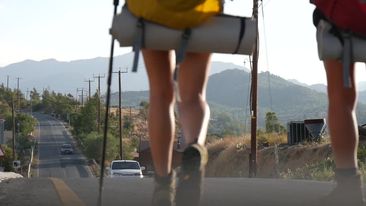 시골 고속도로를 따라 하이킹하는 여성 배낭여행객