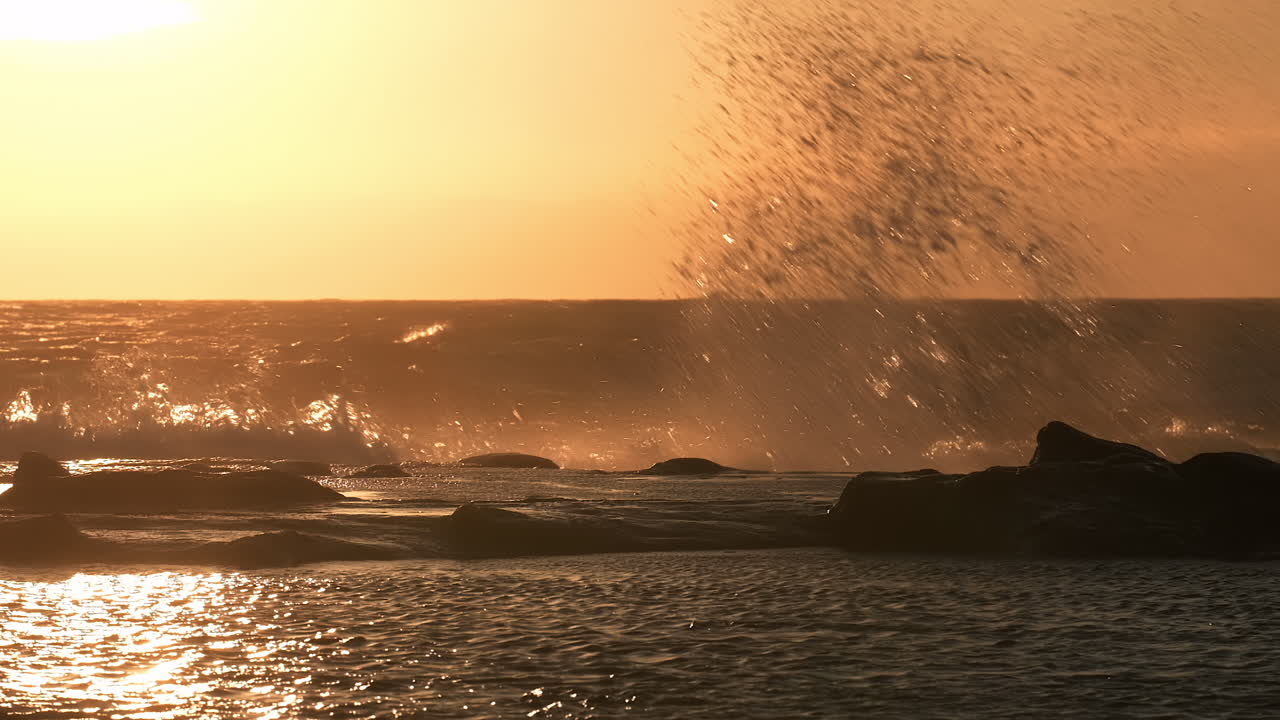 медленное движение волн, разбивающихся на побережье при заходе солнца