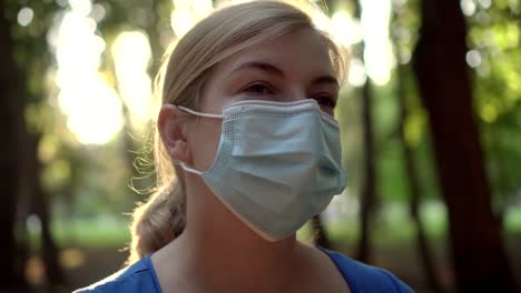 a woman wears a medical mask in a park 02