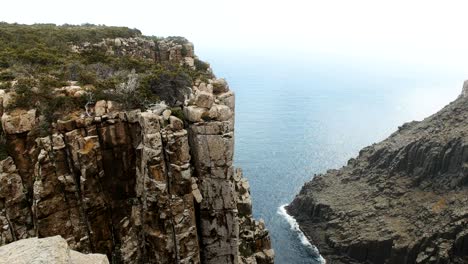 tilt down view of spectacular sea cliffs at cape pillar in tasmania