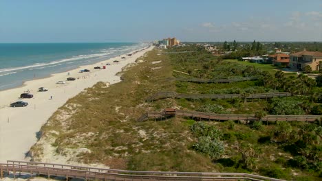 A-wide-profile-aerial-view-of-New-Smyrna-Beach,-Florida-with-beach-homes-on-the-right