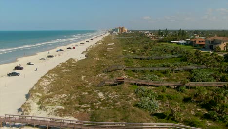 a wide profile aerial view of new smyrna beach, florida with beach homes on the right