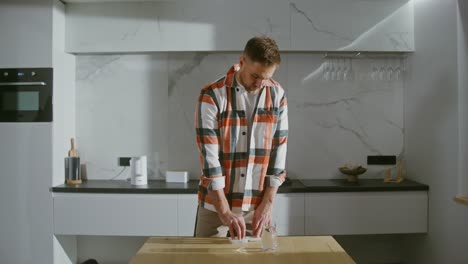 man taking medication in kitchen