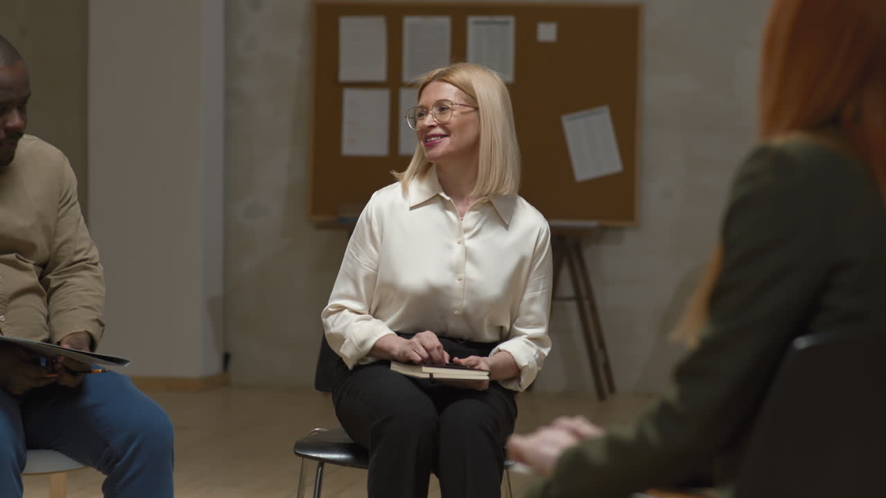 Female Psychologist Greeting People at Group Therapy Session