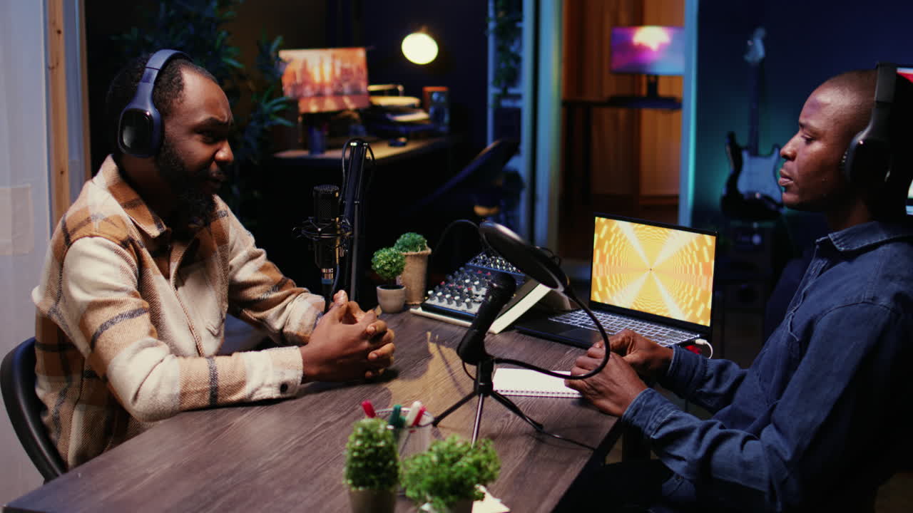 BIPOC men filming online podcast episode, talking with each other, jib down shot