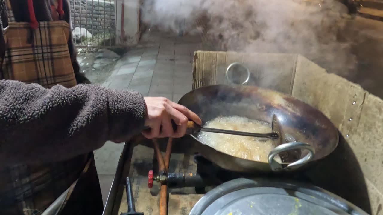 street side food stall frying fish in sri nagar, jammu and kashmir, india. night time