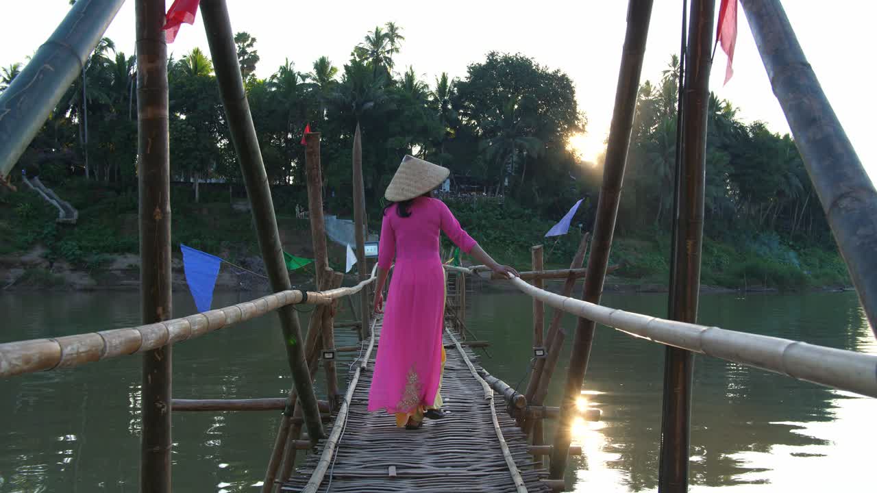 Vietnamese Girl In Traditional Dress Walking On Bamboo Bridge Cross River, Video In 4K
