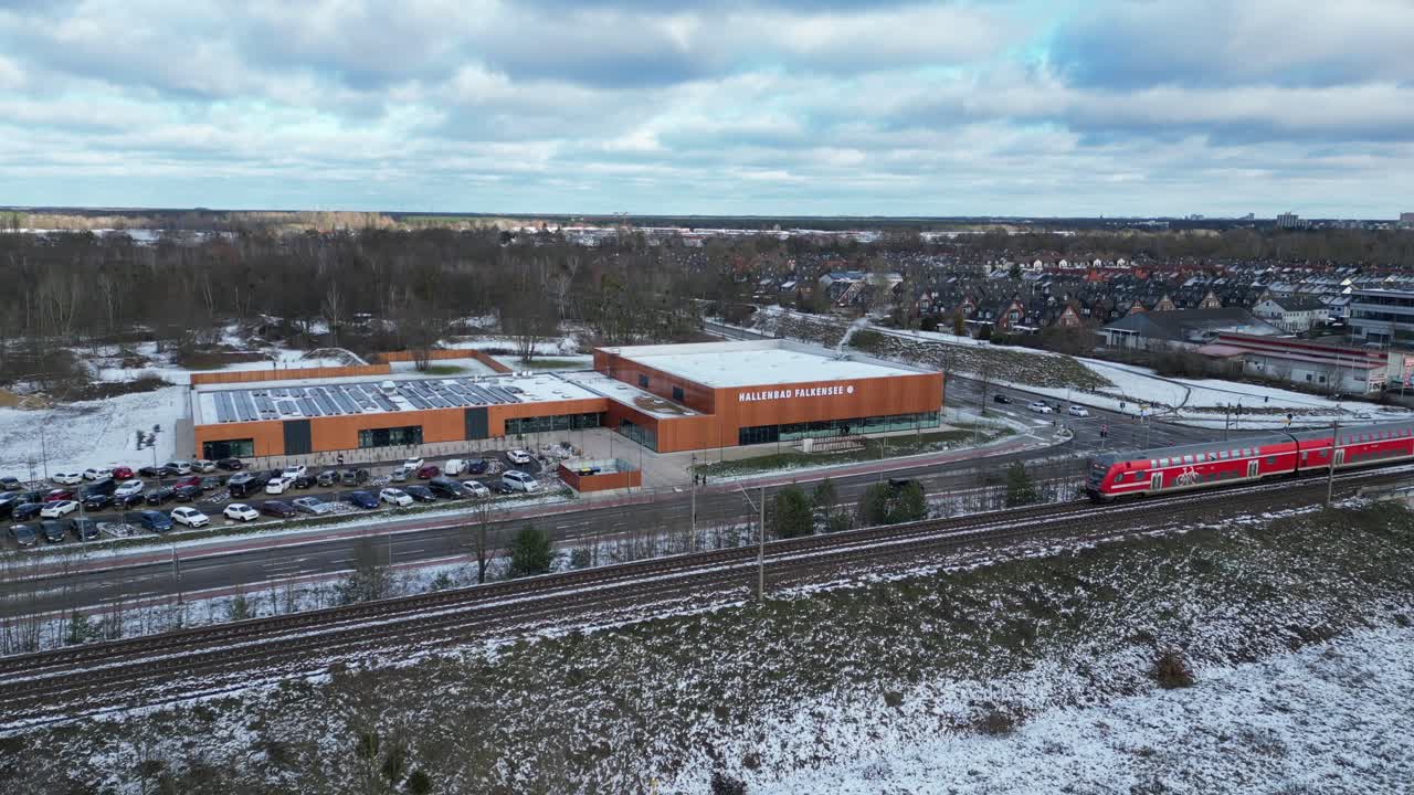 train traveling through a snowy cityscape in segefeld Falkensee. Spectacular aerial view flight static tripod hovering drone