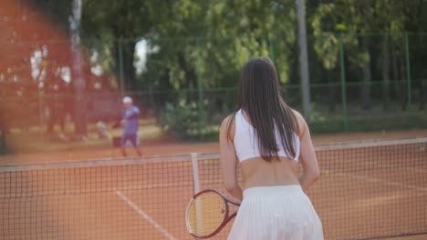 a young woman practicing tennis on an outdoor court with a coach. the coach provides guidance as the player works on her technique, perfecting her strokes in an athletic training session.