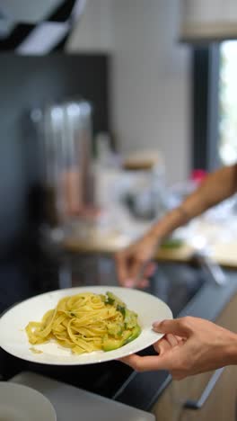 woman cooking pasta with zucchini