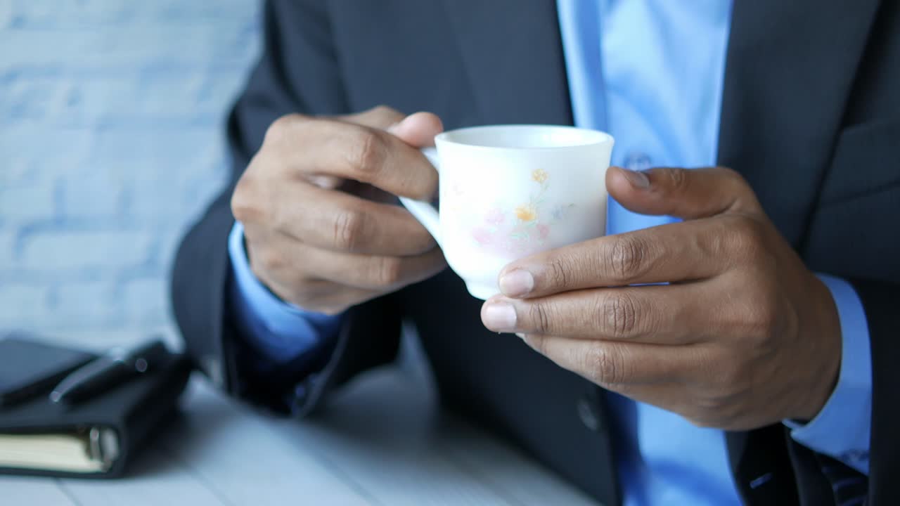 컵 을 들고 있는 슈트 를 입은 남자