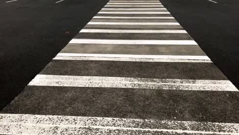 Upward-pan-tilt-of-a-pedestrian-zebra-crossing-at-an-outdoor-car-park