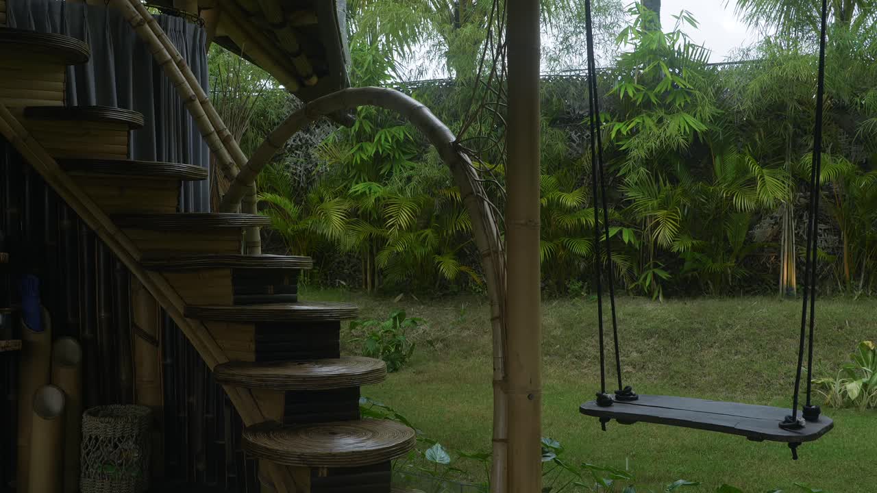 casa de bambú con el columpio lloviendo