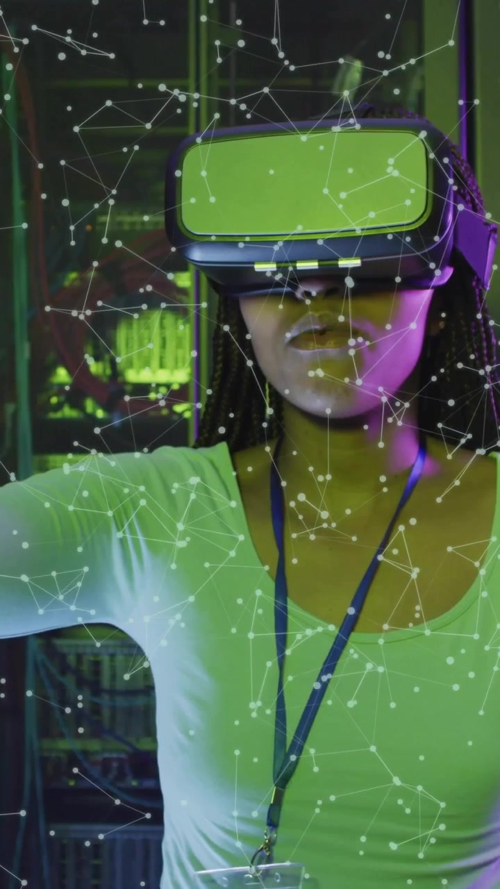 Video verticale: Donna con visore VR e badge che si allunga, selezionando un overlay di rete in laboratorio.