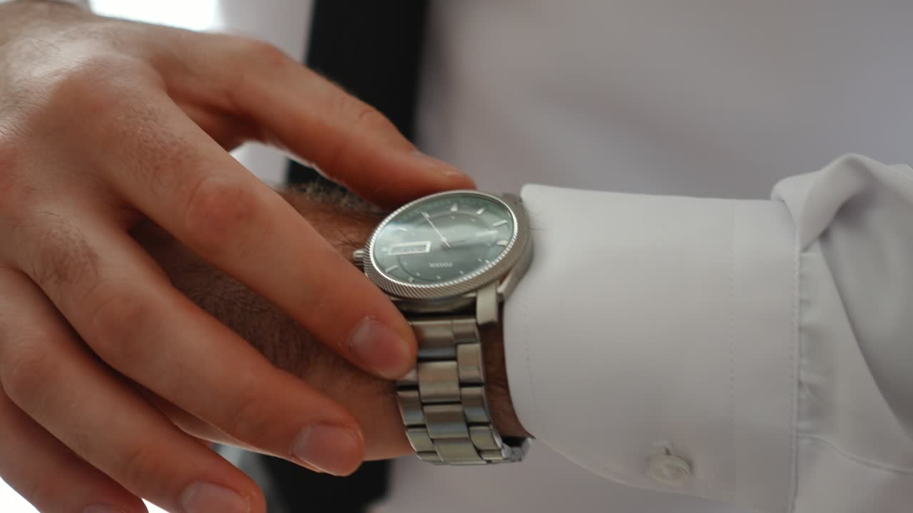 groom's preparing his watch close up