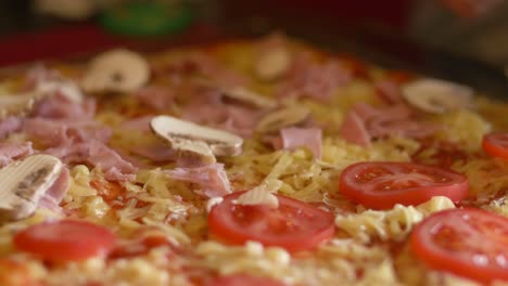 primer plano agregando champiñones a una pizza antes de hornearla