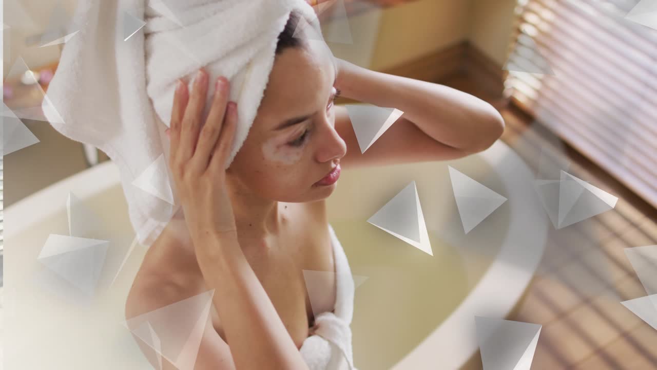 Woman finishing bath and adjusting turban while smoothing towel, beauty wellness triangles drifting