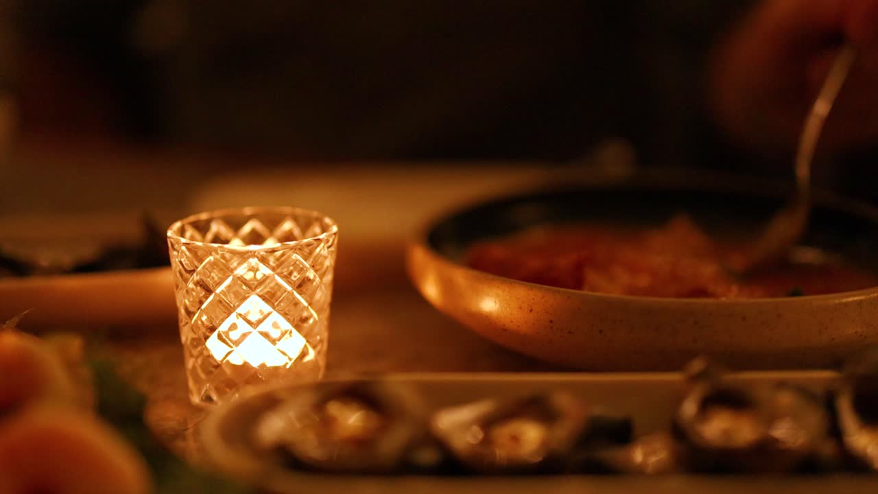 Warm candlelight illuminates a cozy dinner setting with curry, creating an intimate and inviting atmosphere