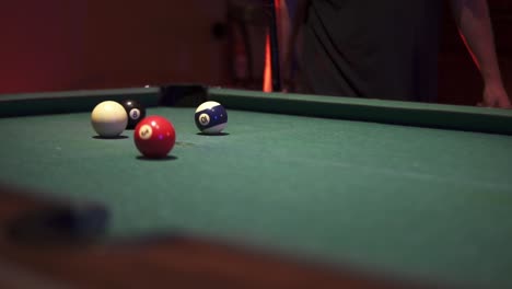white ball rolling over green baize towards her target in the 8 balls pool game