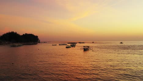 Bahía-Paradisíaca-De-Isla-Tropical-Con-Barcos-De-Pesca-Anclados-En-Una-Laguna-Tranquila-Que-Refleja-Un-Cielo-Dorado-Brillante-Al-Atardecer,-Malasia