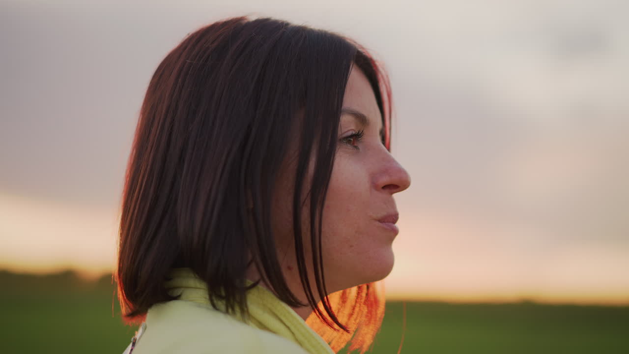 Portrait of woman savoring green apple during sunset, Closeup of woman at sunset experiencing pleasure with apple, Intimate portrait capturing woman with green apple at sunset in peaceful landscape